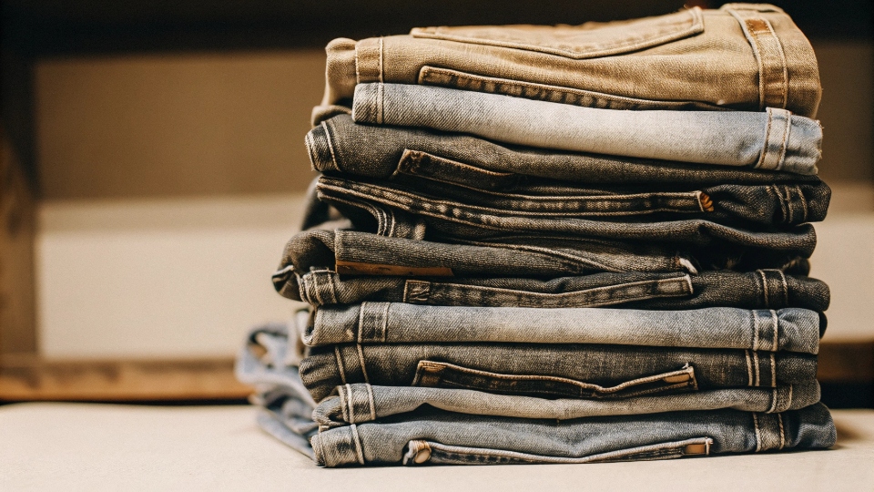 A Stack of Regular Jeans A stack of various pairs of regular, mass-market jeans, all in similar shades of blue.