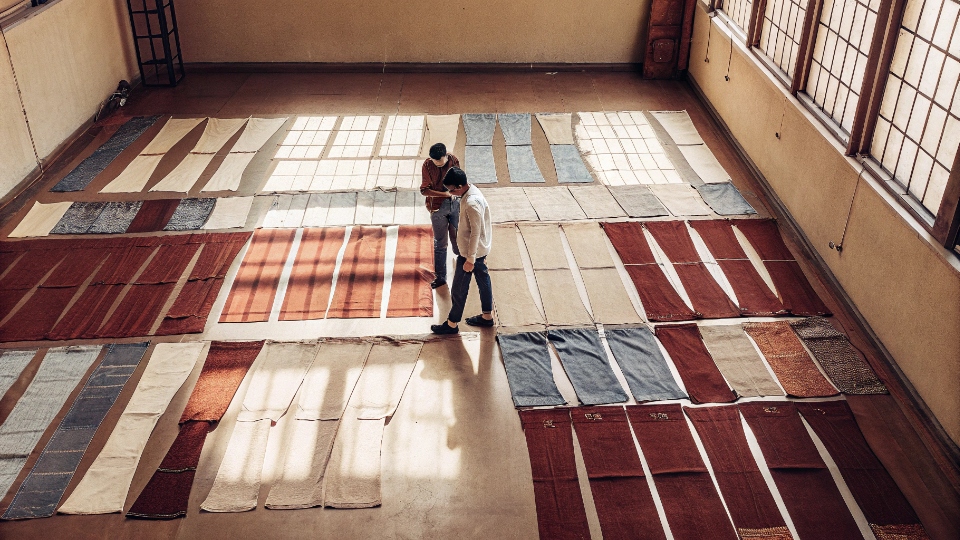 Fabric Consumption for Baggy Jeans An overhead shot of a large denim fabric layout with baggy jean pattern pieces arranged on it.