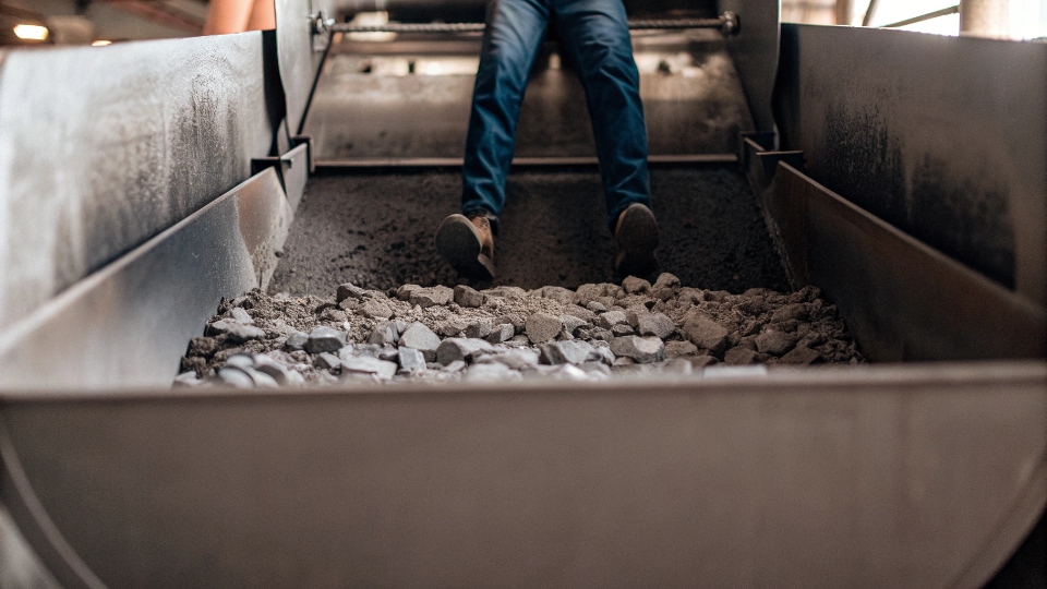 Industrial Stone Washing Process for Denim The inside of a massive industrial washing machine filled with pumice stones and jeans during a stone wash cycle.