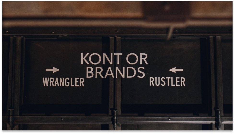 Kontoor Brands Corporate Family Tree A simple graphic showing the Kontoor Brands logo with arrows pointing to the Wrangler and Rustler logos.