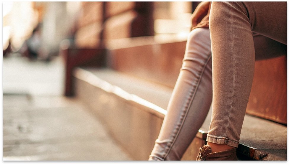 Wrinkles on Skinny Jeans A close-up shot of a person's legs wearing skinny jeans with noticeable wrinkles and bunching around the knees.