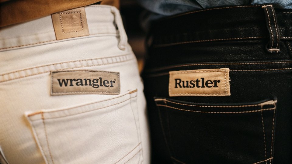 Wrangler vs. Rustler Jean Comparison A side-by-side comparison of a Wrangler jean and a Rustler jean, highlighting subtle differences in the patch and stitching.