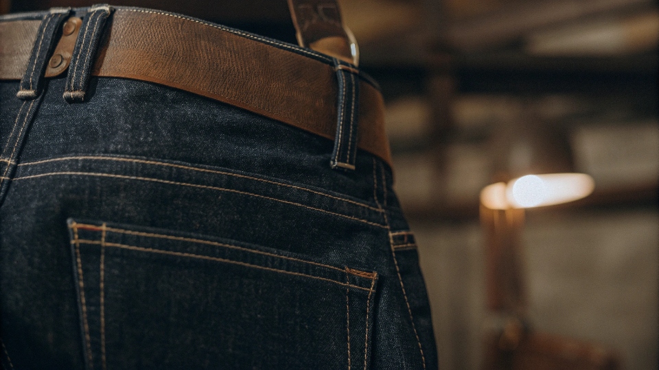 Real vs. Fake Red Monkey Jeans Embroidery A detailed close-up shot comparing the dense, high-quality embroidery of a real RMC jean to the flat, simple stitching of a fake.