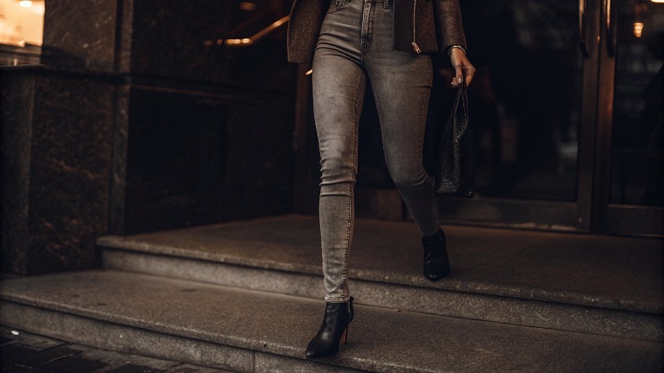 Modern Acid Wash Jeans in Contemporary Street Style A stylish person on a city street wearing modern, grey acid wash jeans as part of a sophisticated outfit.