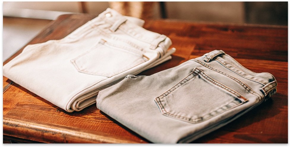 The Classic Light Wash Dad Jean A photo of a pair of light wash, relaxed fit jeans folded neatly on a wooden table.