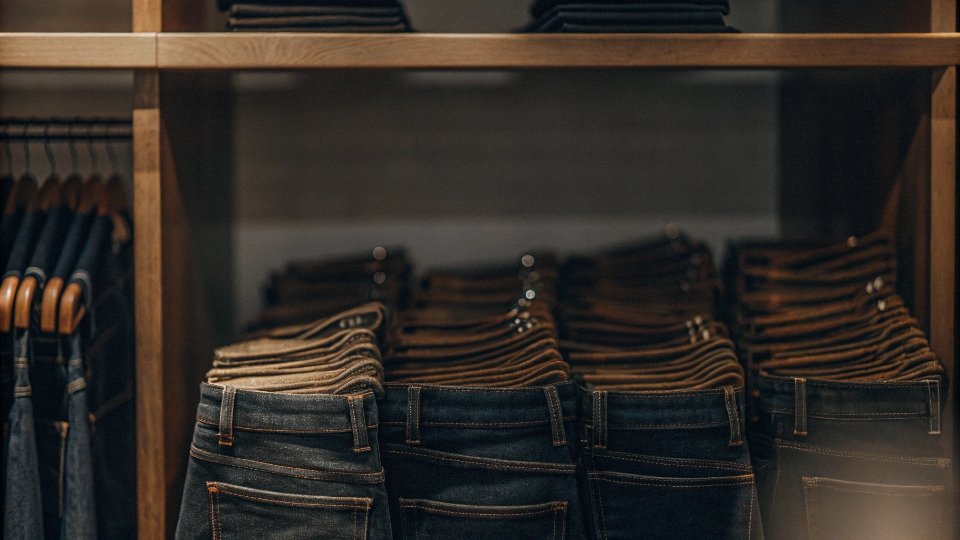 The Ideal Price Point for Quality Denim A display of well-made jeans in a boutique with price tags in the $180 range, representing the sweet spot of quality and value.