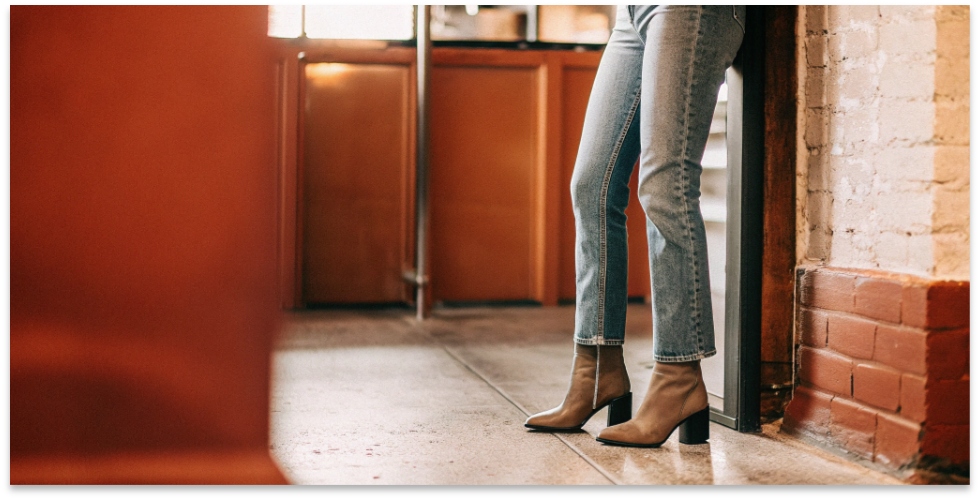 Classic Stovepipe Silhouette A model wearing dark wash stovepipe jeans standing against a white wall, showing the straight line from knee to ankle.