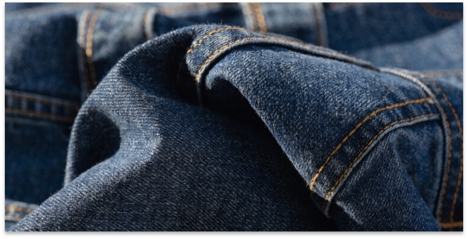 Detail of high-end raw denim jeans A close-up on the intricate fabric and stitching of a premium pair of raw denim jeans.
