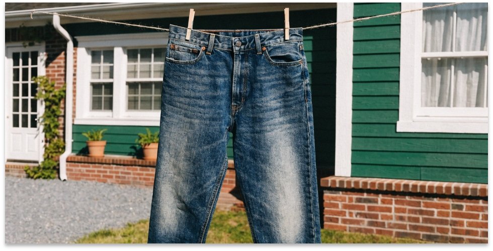 Airing jeans instead of washing them A pair of jeans hanging on a clothesline to air dry.